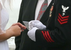 A Marine putting the wedding ring on his financee